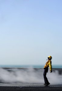 US Navy 111110-N-XE109-647 Aviation Boatswain's Mate (Handling) 2nd Class David J. Nelson braces himself after launching an F-A-18 jet off the fli