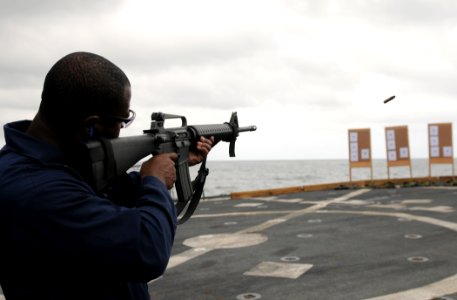 US Navy 111112-N-XQ375-141 Chief Fire Controlman Frank Phillips fires an M16 rifle during a weapons qualification aboard the guided-missile destroy