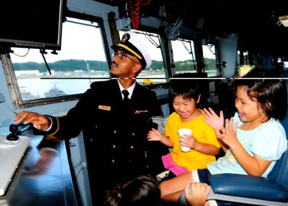 US Navy 111112-N-WJ771-176 Ensign Roberto J. Johnson entertains Japanese children on the bridge of the forward-deployed amphibious dock landing shi