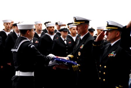 US Navy 111111-N-KF029-400 Capt. Thom Burke receives an American flag during a burial at sea ceremony aboard the aircraft carrier USS Ronald Reagan