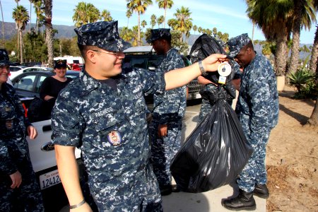 US Navy 111113-N-OM503-008 Operations Specialist 1st Class David Pacheco, from Tularosa, N.M., weighs the last bag of trash collected from East Bea
