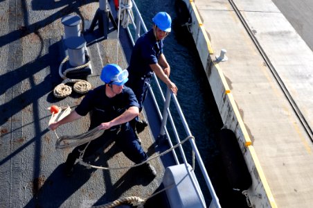 US Navy 111113-N-YX169-069 Seaman Recruit Johannes Hanselmann throws a heaving line from the forcastle of the amphibious transport dock ship USS Po