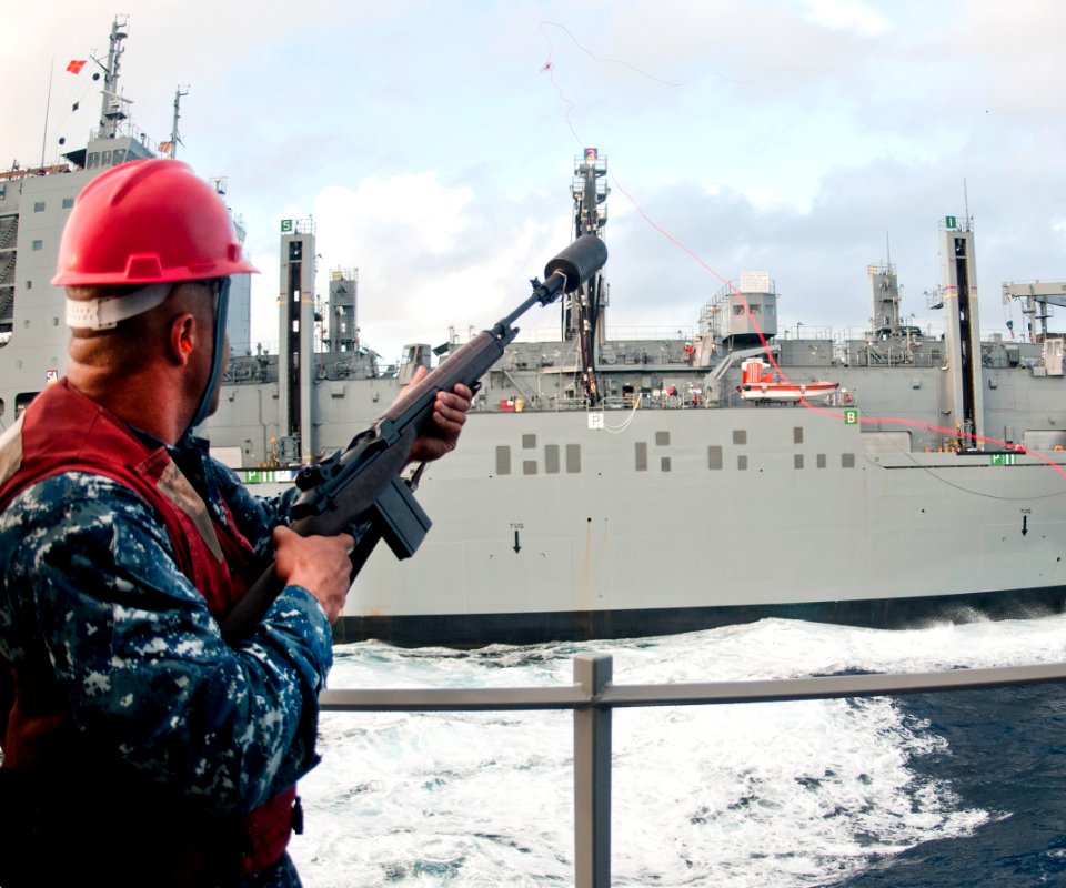 US Navy 111112-N-WX059-221 Gunners Mate 2nd Class Kory Burnett fires a shot line from the guided-missle destroyer USS Chafee (DDG 90) to the Milita