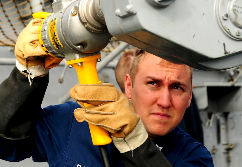 US Navy 111117-N-FH966-482 Fire Controlman 2nd Class Jacob Barnes uses a drill to drive a Sea Sparrow missile into the launcher