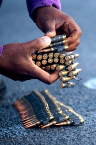 US Navy 111117-N-PB383-080 Aviation Boatswain's Mate (Fuels) Airman Ameyaw Obarima organizes ammunition during a 7.62 × 51 mm NATO live-fire exercise