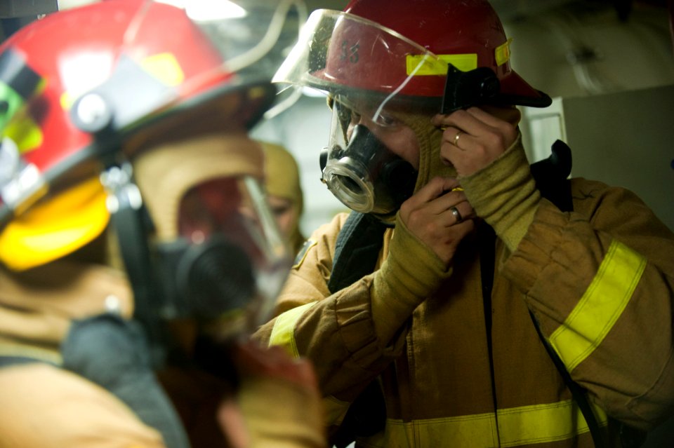 US Navy 111117-N-PB383-580 Engineman 2nd Class Davin Abalama puts on firefighting equipment during a damage control exercise aboard the amphibious