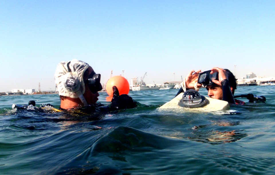 US Navy 111117-N-RP435-081 Explosive Ordnance Disposal Technician 2nd Class Troy Brisol, left, signals to a Royal Bahrain Navy diver that he has su
