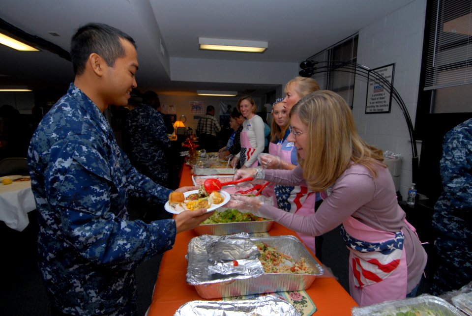 US Navy 111117-N-NK458-012 Jenn Soldow, a member of the Submarine Officer Spouse Association, serves food to Boatswain's Mate 3rd Class Benzon Desa