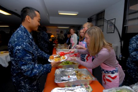 US Navy 111117-N-NK458-012 Jenn Soldow, a member of the Submarine Officer Spouse Association, serves food to Boatswain's Mate 3rd Class Benzon Desa