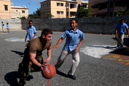 US Navy 111116-A-IP644-039 A Sailor attached to Navy Moblie Construction Battalion (NMCB) 23, dribbles past a Dominican boy during recess