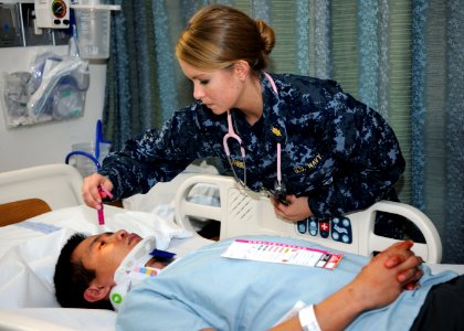 US Navy 111117-N-UB993-082 A Sailor examines a patient during drill