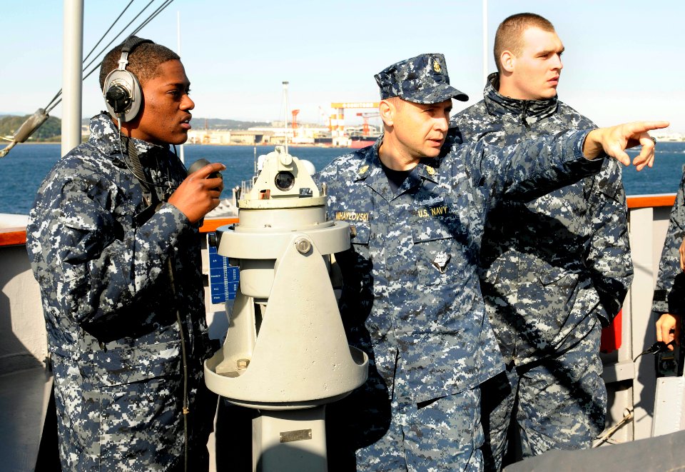 US Navy 111116-N-XG305-460 Chief Quartermaster Andrey Mihaylovski, center, points towards a navigational aid to assist Quartermaster Seamen Korey