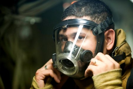 US Navy 111117-N-PB383-571 Engineman 2nd Class Davin Abalama puts on firefighting equipment during a damage control exercise aboard the amphibious