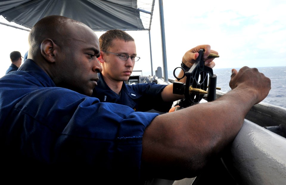 US Navy 111120-N-KS651-183 Lt. j.g. Dustin Holm explains how a sextant works to Senior Chief Master-at-Arms Robert Goode aboard the amphibious dock