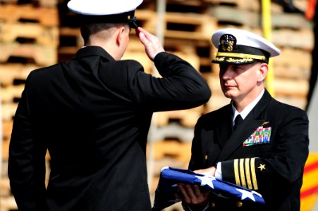 US Navy 111117-N-QL471-197 Capt. Brian E. Luther presents the national ensign to Senior Chief Machinist's Mate Kenneth W. Decker during a burial at photo