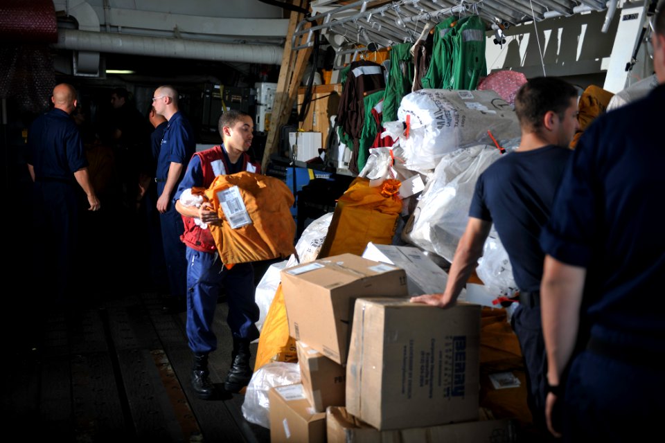 US Navy 111115-N-YZ751-045 Yeoman Seaman Jamal Bryant, center, sorts mail aboard the guided-missile destroyer USS Truxtun (DDG 103) during a replen