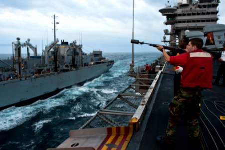 US Navy 111122-N-BT887-046 Gunner's Mate 2nd Class Phillip Grauer, from Sheridan, Ore., fires a phone and distance line to the Military Sealift Com