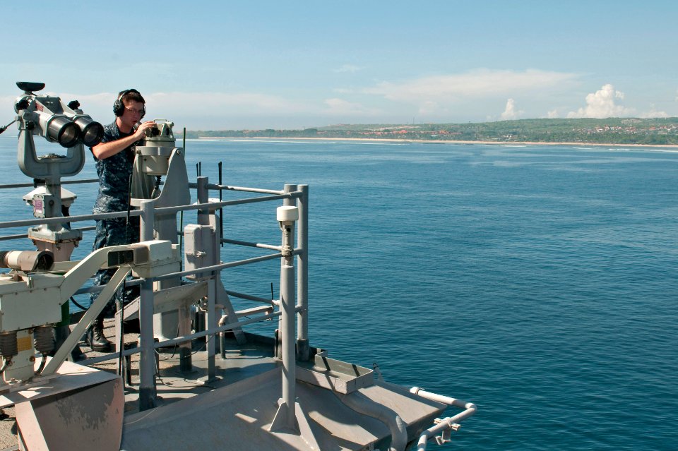 US Navy 111120-N-MW330-021 Quartermaster Seaman Shannon Trippe measures the distance from land to ship through an alidade