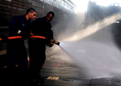 US Navy 111121-N-WJ771-048 Sailors man a fire hose during a crash and salvage drill photo