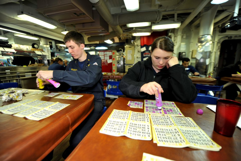 US Navy 111122-N-YZ751-153 Ensign Richard W. Gochnauer, left, and Lt. j.g. Cassandra E. Hauser play bingo on the mess decks aboard the guided-missi