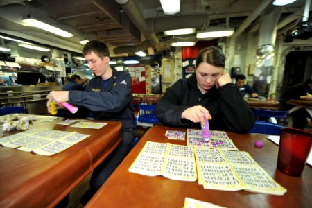 US Navy 111122-N-YZ751-153 Ensign Richard W. Gochnauer, left, and Lt. j.g. Cassandra E. Hauser play bingo on the mess decks aboard the guided-missi