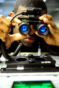 US Navy 111121-N-QL471-087 Aviation Electrician's Mate Airman Randy Harmon performs tests on a night vision scope aboard the aircraft carrier USS G