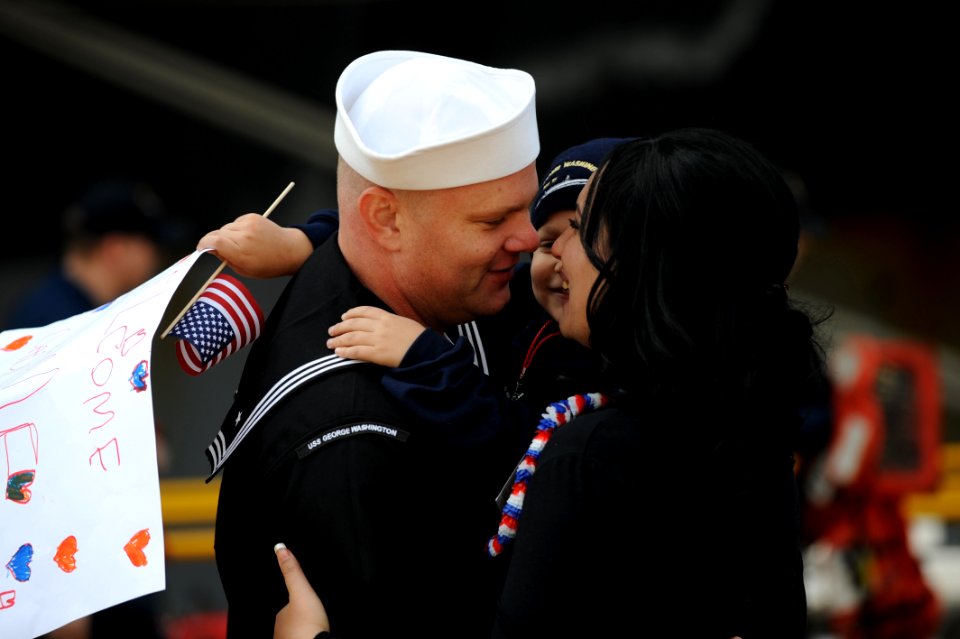 US Navy 111122-N-DS193-006 A Sailor greets his wife and son after returning from deployment