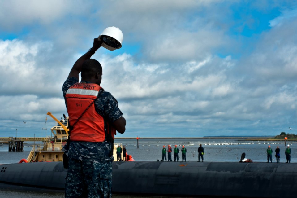 US Navy 111123-N-FG395-034 Boatswain's Mate 1st Class Travis White, from West Palm Beach, Fla., waves as the Ohio-class ballistic missile submarine