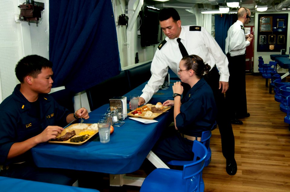US Navy 111124-N-ER662-060 Senior Chief Gas Turbine Systems Electrical Cliff Calvales serves beverages to sailors during Thanksgiving dinner aboard