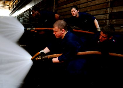 US Navy 111121-N-WJ771-146 Sailors man a fire hose during a crash and salvage drill photo