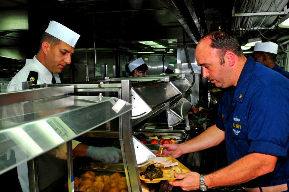 US Navy 111124-N-ER662-076 Chief Damage Controlman Joseph D. Kazmierski serves Sailors during Thanksgiving dinner