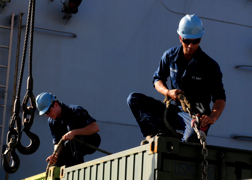 US Navy 111128-N-WJ771-041 Sailors assigned to the forward-deployed amphibious dock landing ship USS Tortuga (LSD 46) attach cables to a cargo cont