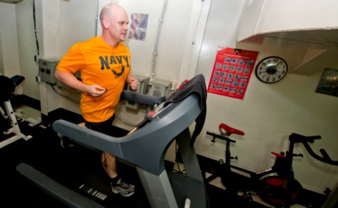 US Navy 111126-N-OY799-489 Chief Machinist's Mate Adam Reed runs five kilometers on a treadmill in the chief's gym aboard the Nimitz-class aircraft