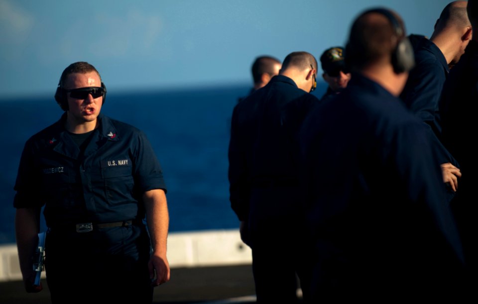 US Navy 111129-N-PB383-302 Gunner's Mate 2nd Class Adrian Rodziewicz Rogers observes for safety as the primary line coach during small arms qualifi
