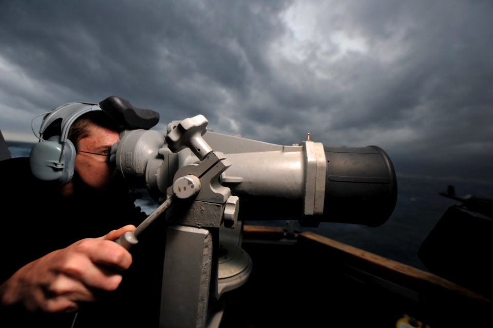 US Navy 111122-N-YZ751-101 Operations Specialist Seaman Anthony C. Tyrrell looks through the ship's big eyes on the bridge wing aboard the guided-m