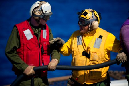 US Navy 111129-N-PB383-707 Aviation Boatswain's Mate (Fuels) 3rd Class James Lising explains how to properly man a fire hose to a Marine during a f