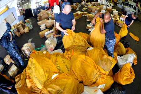 US Navy 111126-N-KM175-021 Sailors aboard the forward-deployed amphibious assault ship USS Essex (LHD 2) sort mail received from the Military Seali