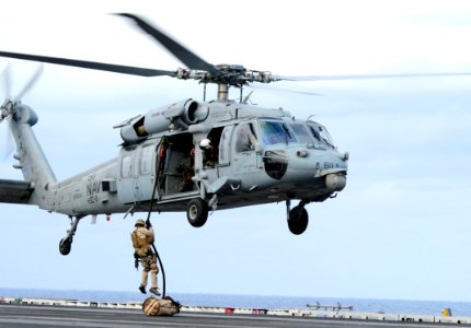 US Navy 111209-N-QL471-296 A member of an explosive ordnance disposal team fast ropes onto the flight deck