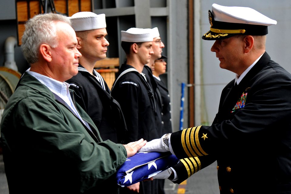 US Navy 111209-N-XE109-085 A Sailor presents the national ensign