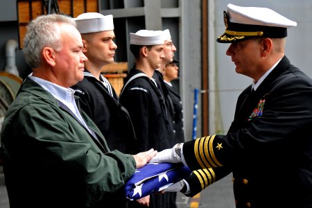 US Navy 111209-N-XE109-085 A Sailor presents the national ensign