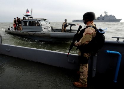 US Navy 111213-N-NR955-173 Operations Specialist Matthew A. Hypes stands guard aboard the Navy auxiliary ship USS Hugo (NS-8201)