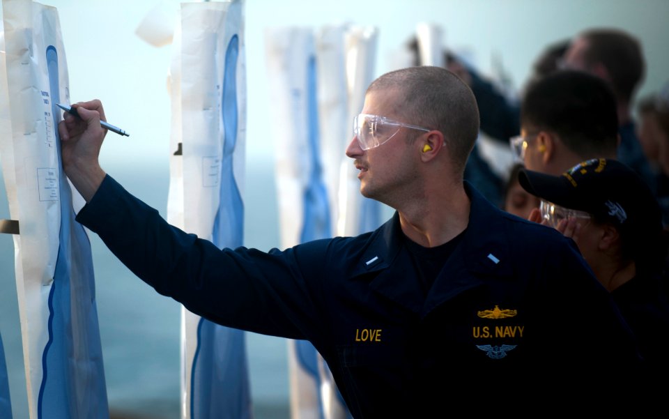 US Navy 111210-N-PB383-302 Lt. j.g. Patrick Love writes his name on a target during small arms qualifications aboard the amphibious transport dock