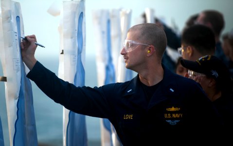 US Navy 111210-N-PB383-302 Lt. j.g. Patrick Love writes his name on a target during small arms qualifications aboard the amphibious transport dock
