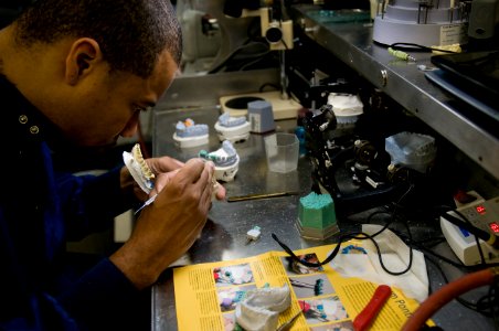 US Navy 111213-N-TZ605-100 Hospital Corpsman 1st Class Xavier Johnson, assigned to the dental department aboard the Nimitz-class aircraft carrier U