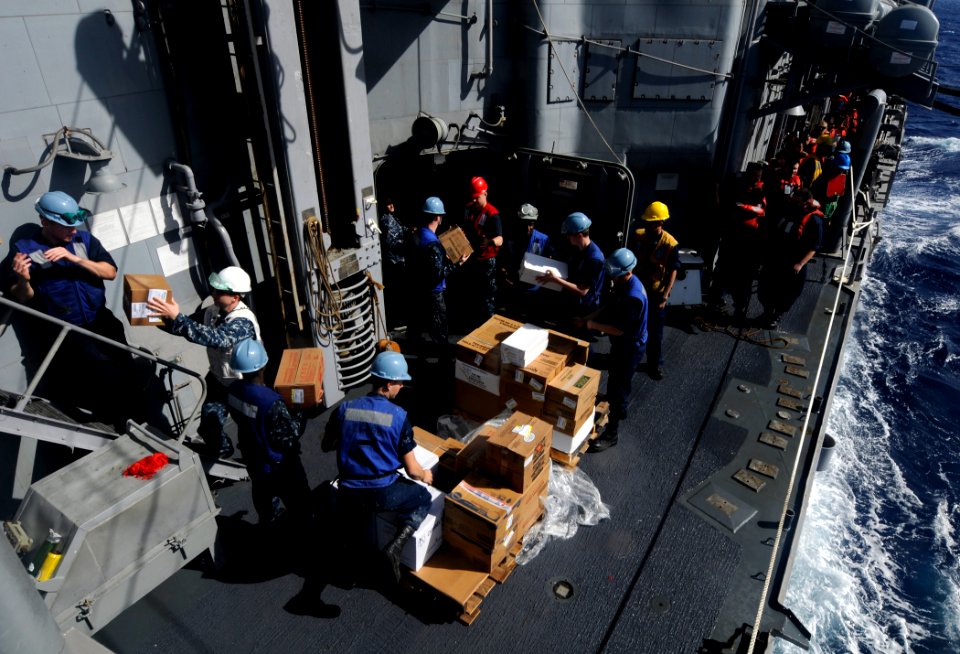 US Navy 111211-N-BC134-374 Sailors aboard the guided-missile cruiser USS Bunker Hill (CG 52) unload supplies during an underway replenishment