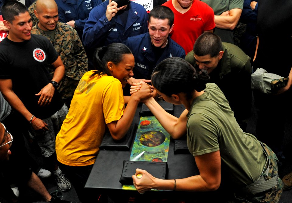 US Navy 111211-N-DX615-040 Seaman Denise Williams and Marine Sgt. Amanda Joseph, participate in an arm wrestling competition aboard the amphibious
