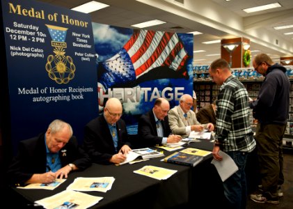 US Navy 111210-N-XK513-016 Medal of Honor recipients autograph the book