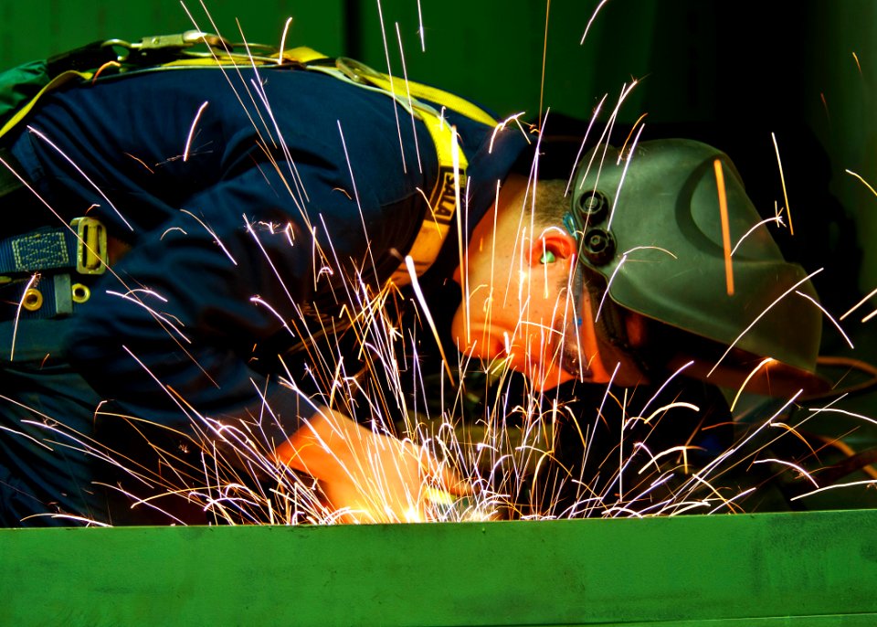 US Navy 111214-N-BT887-450 A Sailor grinds the edge of a storage unit