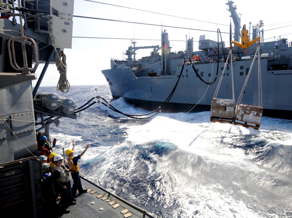 US Navy 111211-N-BC134-345 Sailors aboard the guided-missile cruiser USS Bunker Hill (CG 52) guide pallets of supplies onto the ship during an unde