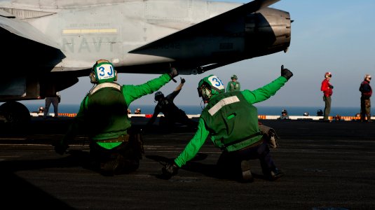 US Navy 111214-N-OY799-156 Final checkers give the safe for launching signal to the jet pilot